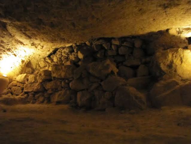 A wall of stacked boulders seen from inside the cave, blocking the way out β you cannot see past it.