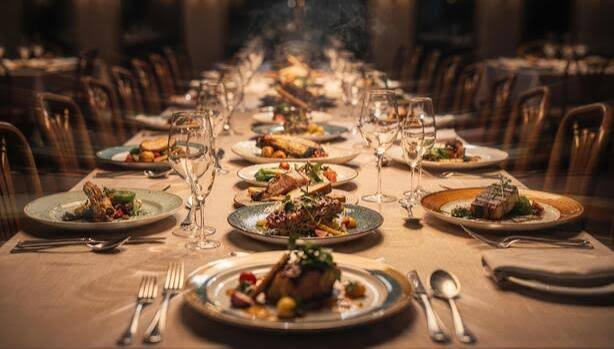 A long table set the length of a room, plates and glasses down both sides β everyone at the same table.